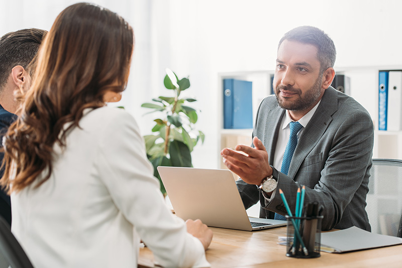 Mies ja nainen tapaamassa lakimiestä toimistossa